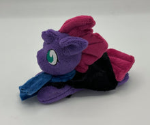 Load image into Gallery viewer, Purple colored horse plush laying on belly with maroon Mohawk hair. Eye is green. Wears a black cape and blue scarf 
