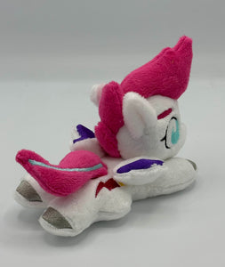 White horse plush laying on belly with pink lightning bolt on flank and pink with blue stripe hair. Eye is blue. Has purple tipped wings and silver hooves.