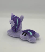 Load image into Gallery viewer, Purple horse plush laying on belly with purple star and black equals sign on flank and purple with blue stripe hair. Eye is purple.
