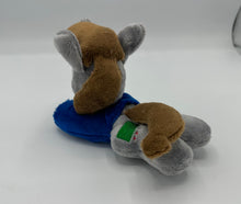 Load image into Gallery viewer, Grey horse plush laying on belly with green square on flank and two brown hair. Eye is green. Wears a blue shirt.
