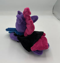 Load image into Gallery viewer, Purple colored horse plush laying on belly with maroon Mohawk hair. Eye is green. Wears a black cape and blue scarf 
