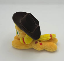 Load image into Gallery viewer, Orange horse plush laying on belly with red apples on flank and yellow hair with red hair ribbons. Eye is green. Wears a brown hat.

