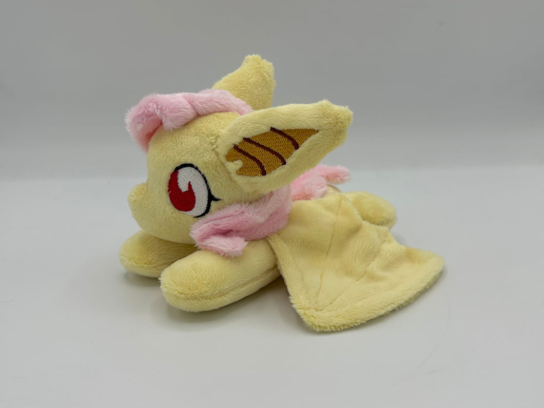 Yellow horse laying on belly with yellow bat wings and big yellow and gold bat ears. Has pink hair. Has red eyes. Has pink bats on flank. 