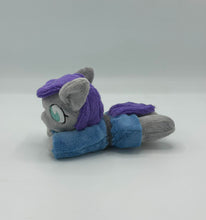 Load image into Gallery viewer, Grey horse plush laying on belly with purple hair. Eye is blue. Wears a blue dress with a grey belt
