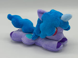 Purple horse plush laying on belly with blue heart on flank and blue hair. Eye is maroon.