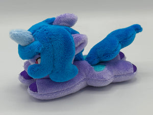 Purple horse plush laying on belly with blue heart on flank and blue hair. Eye is maroon.