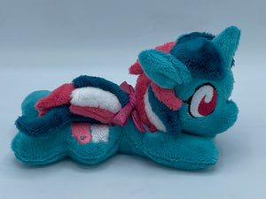 Blue/green horse plush laying on belly with pink and white icecream float on flank and green/pink/white hair. Eye is maroon.