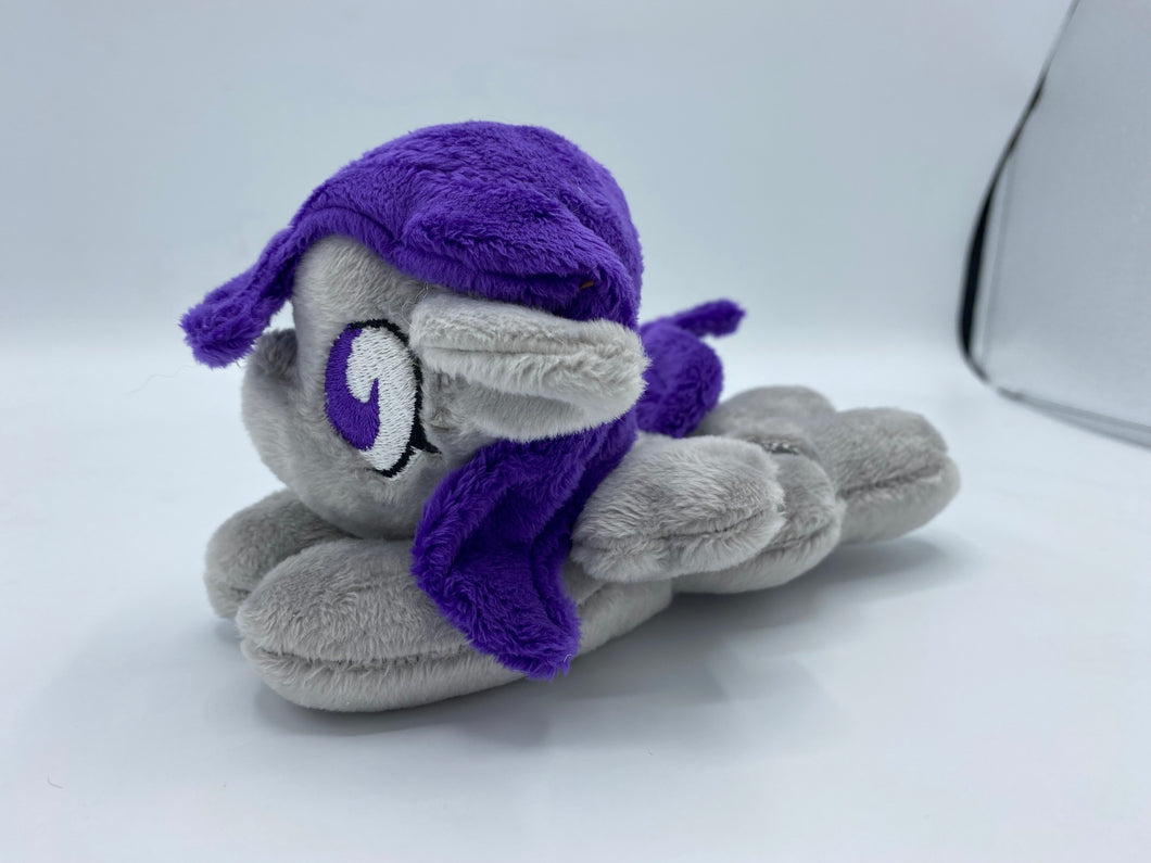 Grey horse plush laying on belly with silver lightning bolt on flank and purple hair. Eye is purple.