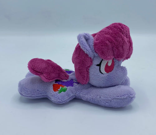 Purple horse plush laying on belly with colorful fruit on flank and maroon hair. Eye is red.