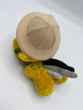 Load image into Gallery viewer, Gold colored horse plush laying on belly with green and gold compass on flank and her hair is grey shades. Eye is maroon. Wears a green shirt and safari hat
