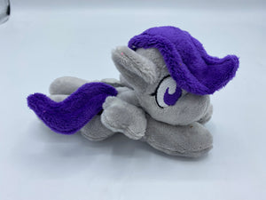 Grey horse plush laying on belly with silver lightning bolt on flank and purple hair. Eye is purple.