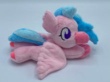 Load image into Gallery viewer, Pink hippogriff plush laying on belly. She has pink bird front feet and pink hooves on back feet. She has pink wings and a pink beak. Her eyes are purple. She has a pink ear that looks like feathers. Her hair is two tone blue. 
