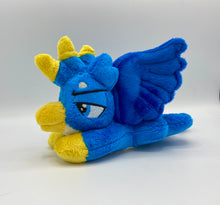 Load image into Gallery viewer, Blue gryphon plush laying on belly. Has a cream belly. Tail is a long lion tail tipped in dark blue. Has dark blue wings. Back feet are paws and front feet are yellow like bird feet. Has a yellow beak and a blue eye. Has feathers on had that are blue and yellow. Ears are blue and look like feathers. 
