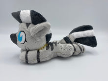 Load image into Gallery viewer, A zebra plush laying on belly. The coat is grey with black stripes. There is a grey sun design on the flank. She has a dark grey muzzle. Hair is white and grey stripes. Eye is blue. She has a gold chain around her neck. 
