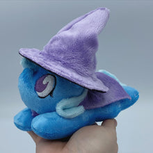 Load image into Gallery viewer, Blue horse plush laying on belly with blue wand on flank and blue hair. Eye is purple. Wearing a purple starry cape
