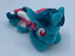 Blue/green horse plush laying on belly with pink and white icecream float on flank and green/pink/white hair. Eye is maroon.