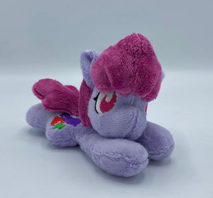 Purple horse plush laying on belly with colorful fruit on flank and maroon hair. Eye is red.
